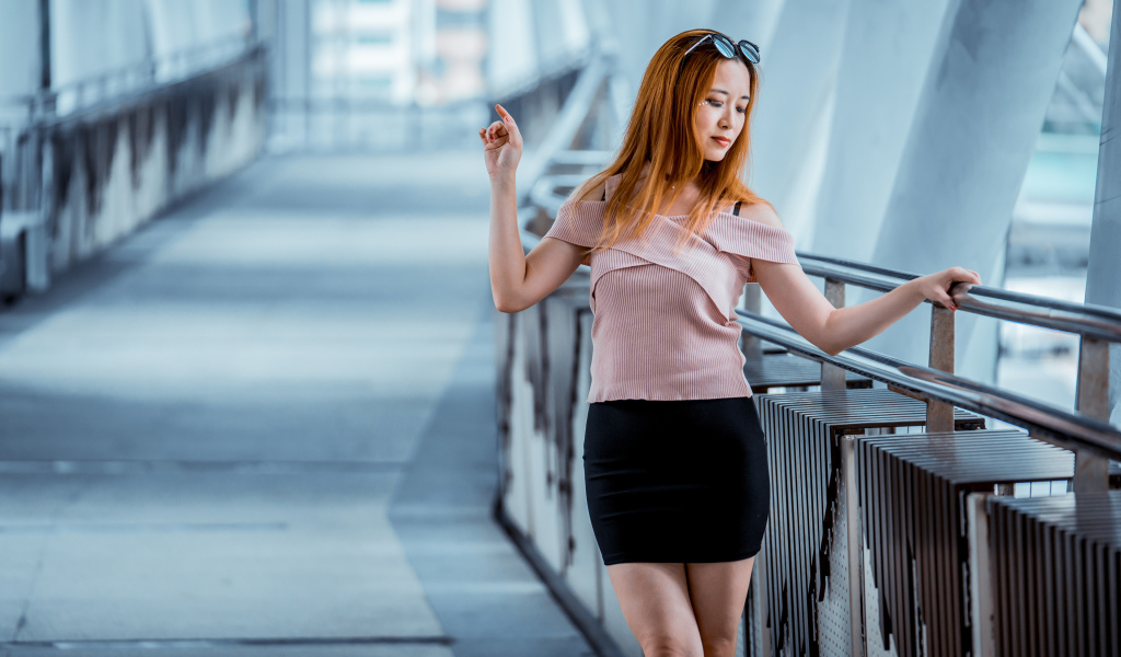 Красивая рыжеволосая девушка азиатка в черной юбке