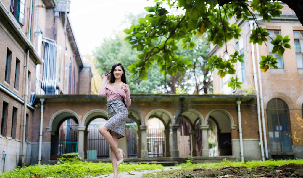 Красивая стройная азиатка на фоне здания