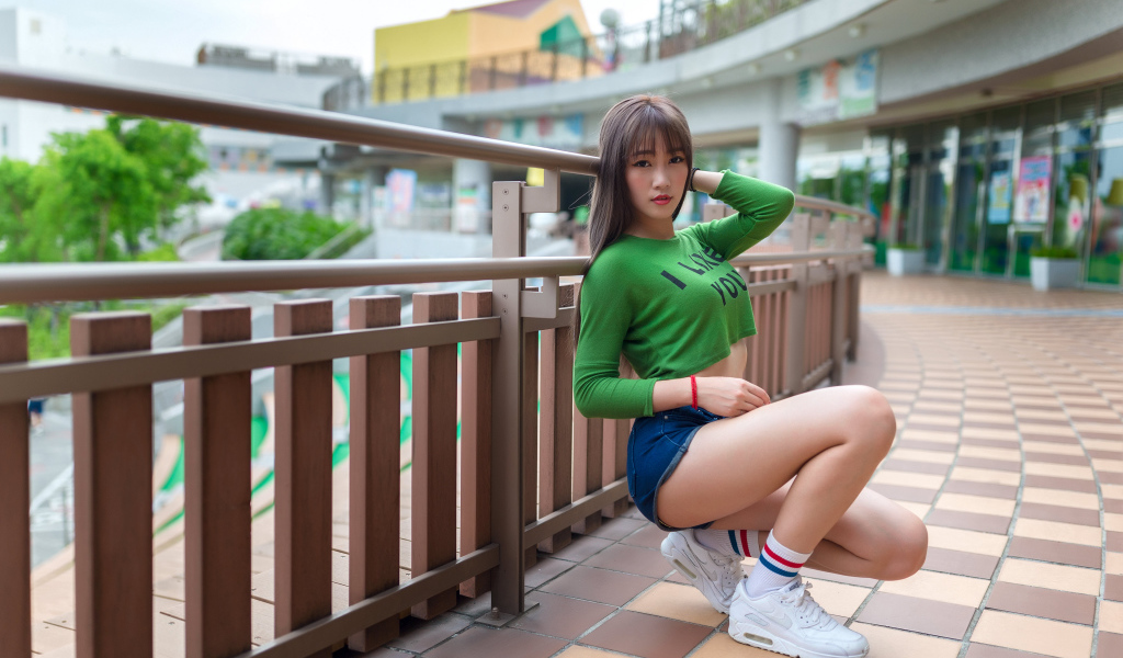 Красивая молодая азиатка в белых кроссовках 