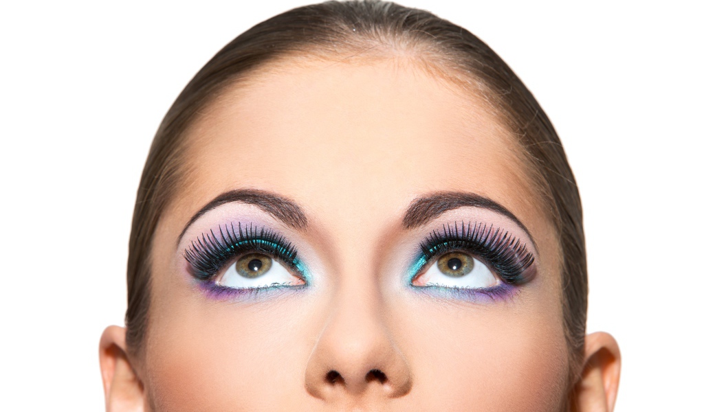 Яркий макияж на глазах у девушки на белом фоне