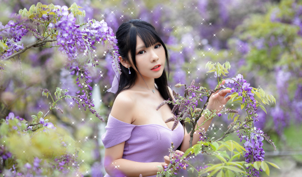 Кареглазая азиатка у куста с цветами глицинии