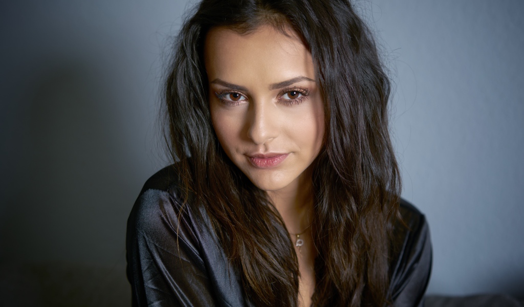 Кареглазая брюнетка в черном халате на сером фоне