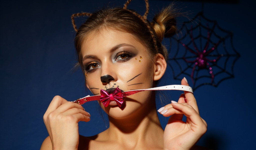 Девушка кошка с красным бантиком во рту 