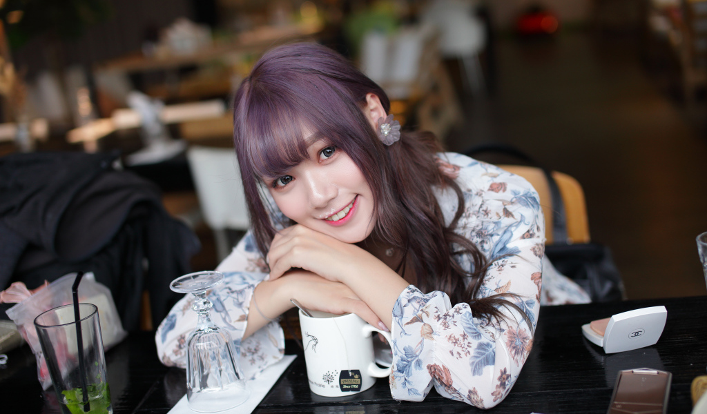 Милая девушка азиатка сидит за столиком