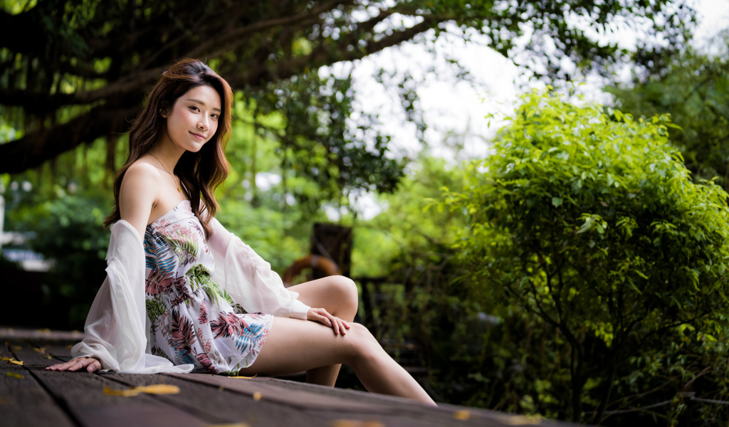 Милая девушка азиатка сидит на мосту