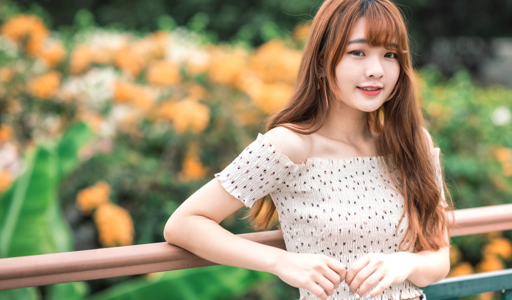 Милая девушка азиатка стоит у перил