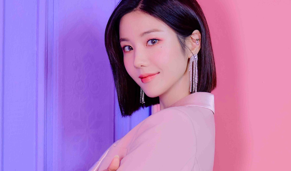Милая девушка азиатка с короткой стрижкой на розовом фоне 