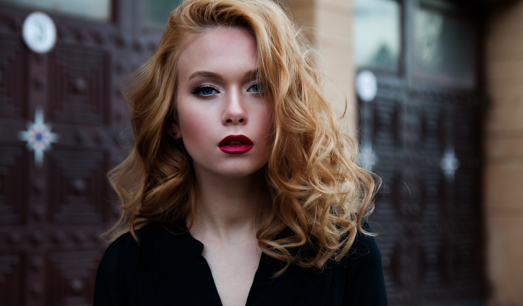 Милая блондинка с красными губами у дома