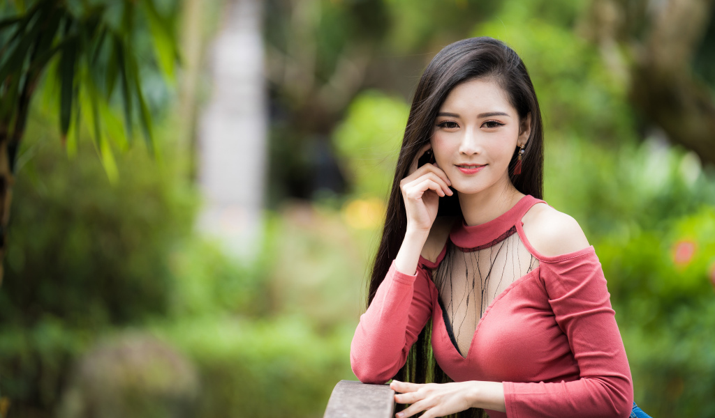 Милая улыбающаяся девушка азиатка розовой кофте