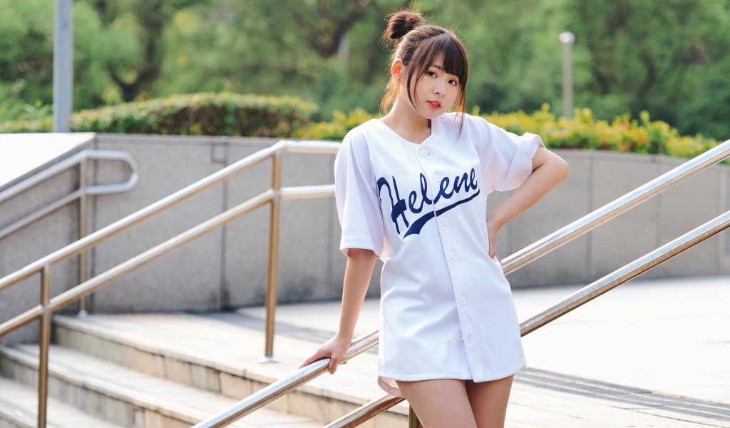 Симпатичная молодая азиатка стоит у перил