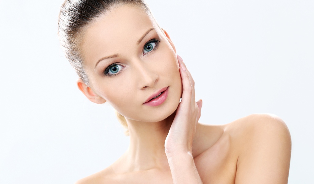 Нежная голубоглазая девушка без макияжа на белом фоне