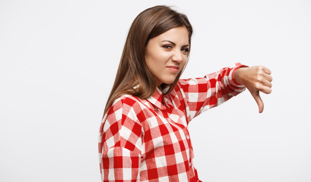 Недовольная девушка опустила палец вниз 