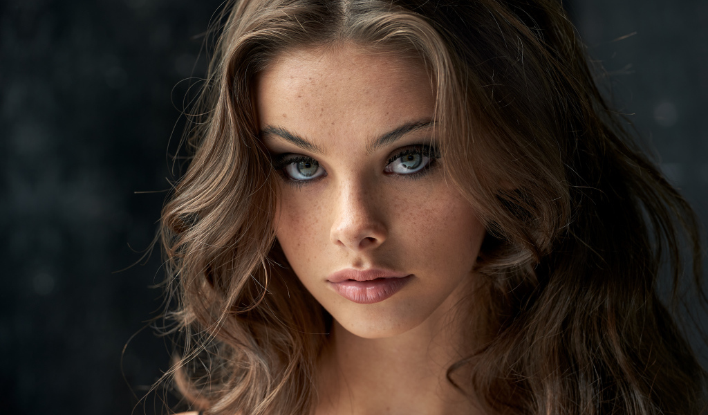 Лицо красивой девушки с веснушками на лице 