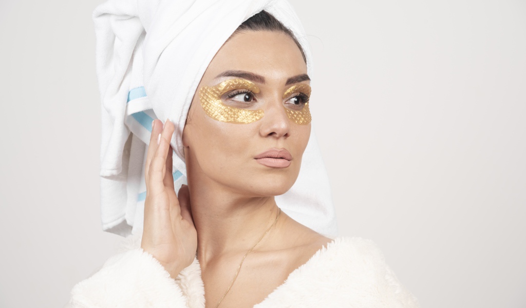 Девушка после душа с золотыми патчами под глазами