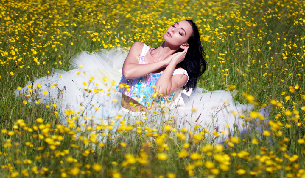 Девушка в красивом платье на траве с желтыми цветами