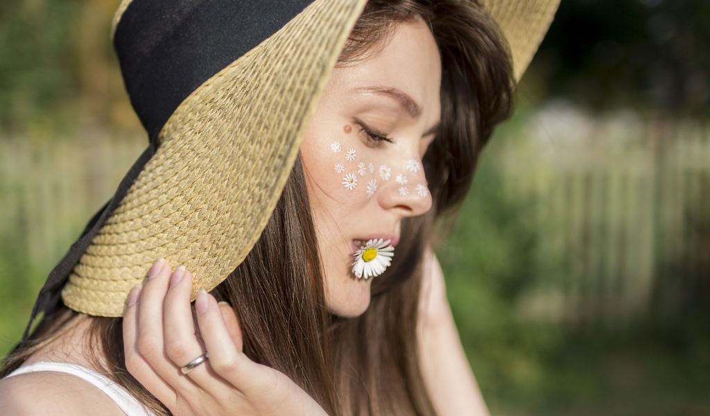 Девушка в шляпе с ромашкой в зубах 