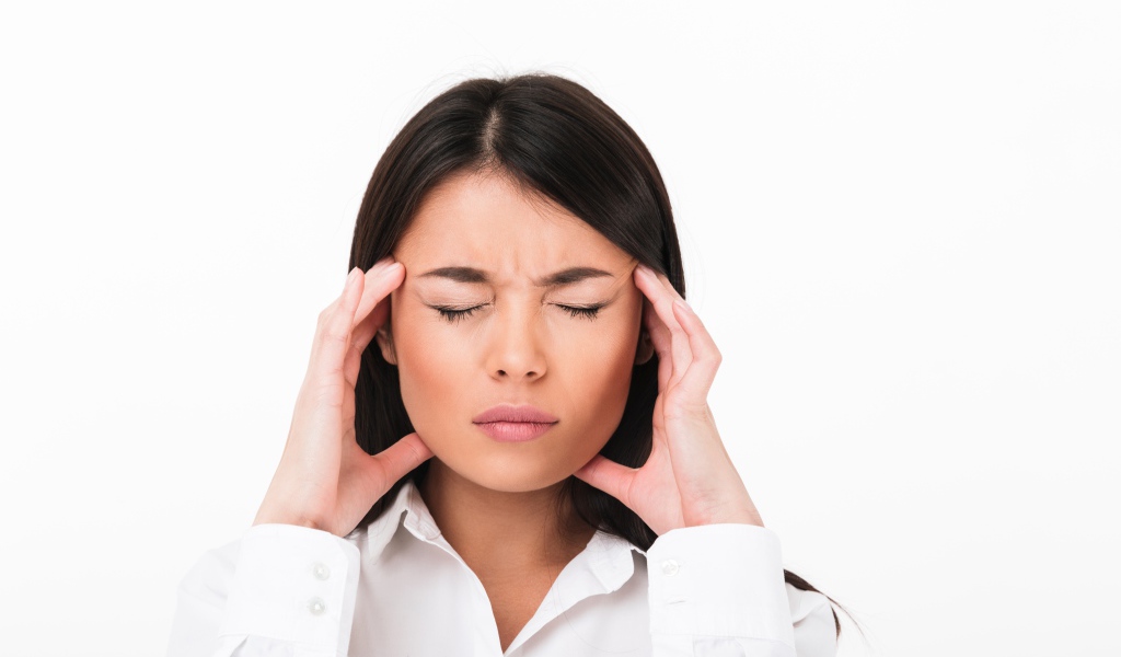 Девушка с головной болью на белом фоне 