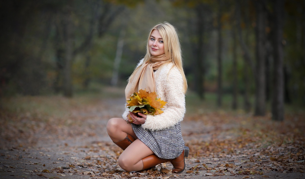 Девушка с листьями на дороге осенью
