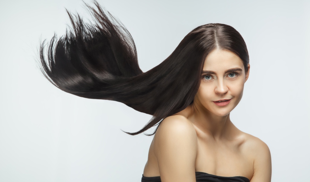 Длинные шелковистые волосы молодой брюнетки 