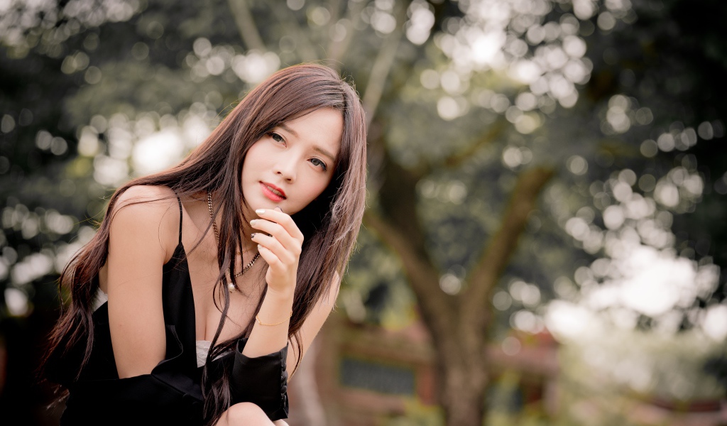 Задумчивая девушка азиатка в черном платье 