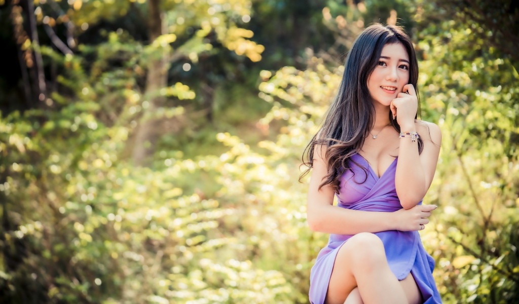 Улыбающаяся девушка азиатка в сиреневом платье