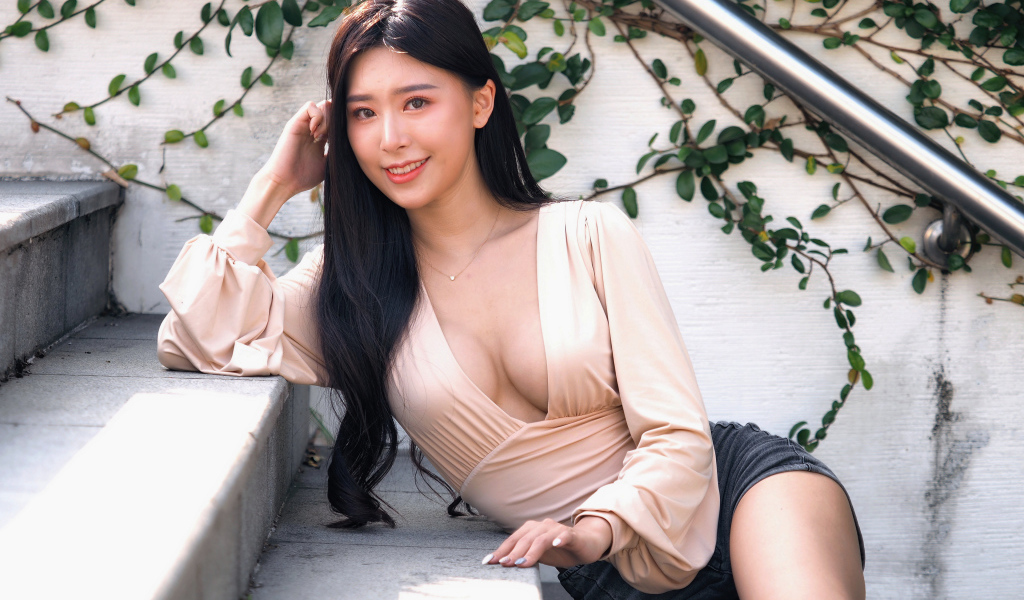 Улыбающаяся девушка азиатка с черными волосами на ступенях 