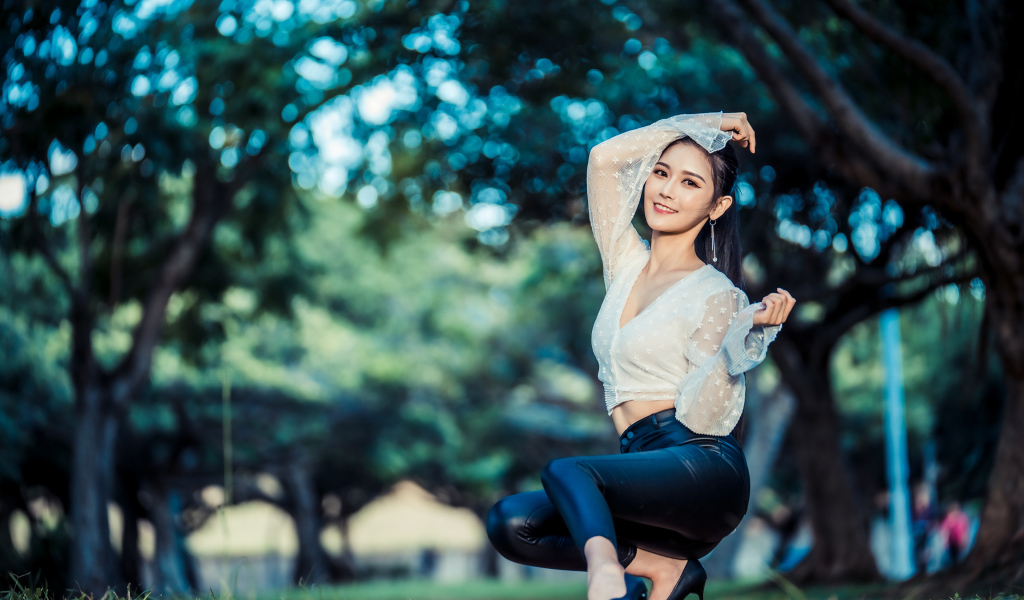 Улыбающаяся азиатка в черных брюках