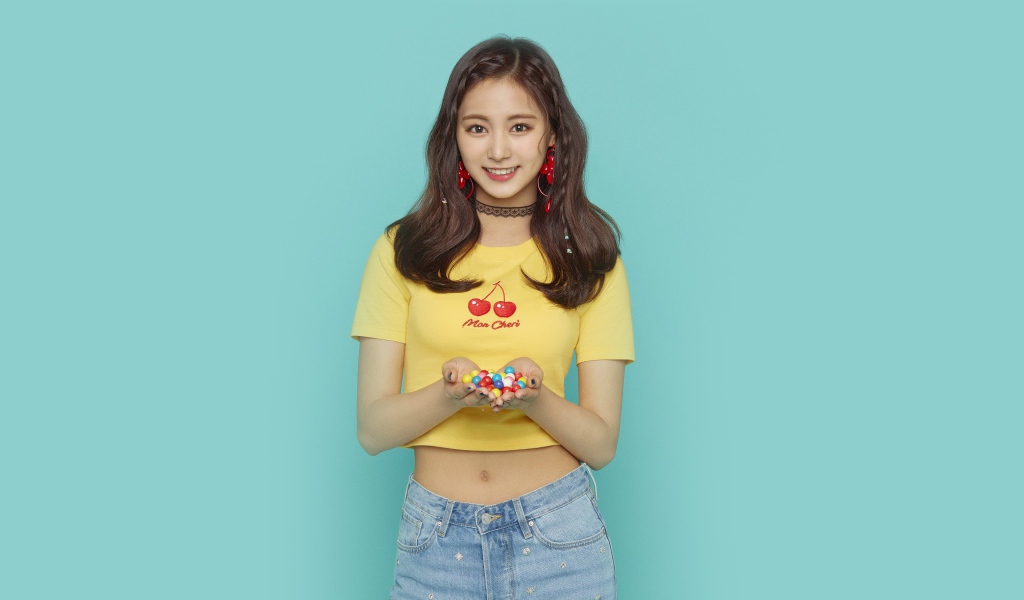 Улыбающаяся девушка с конфетами в ладонях на голубом фоне 