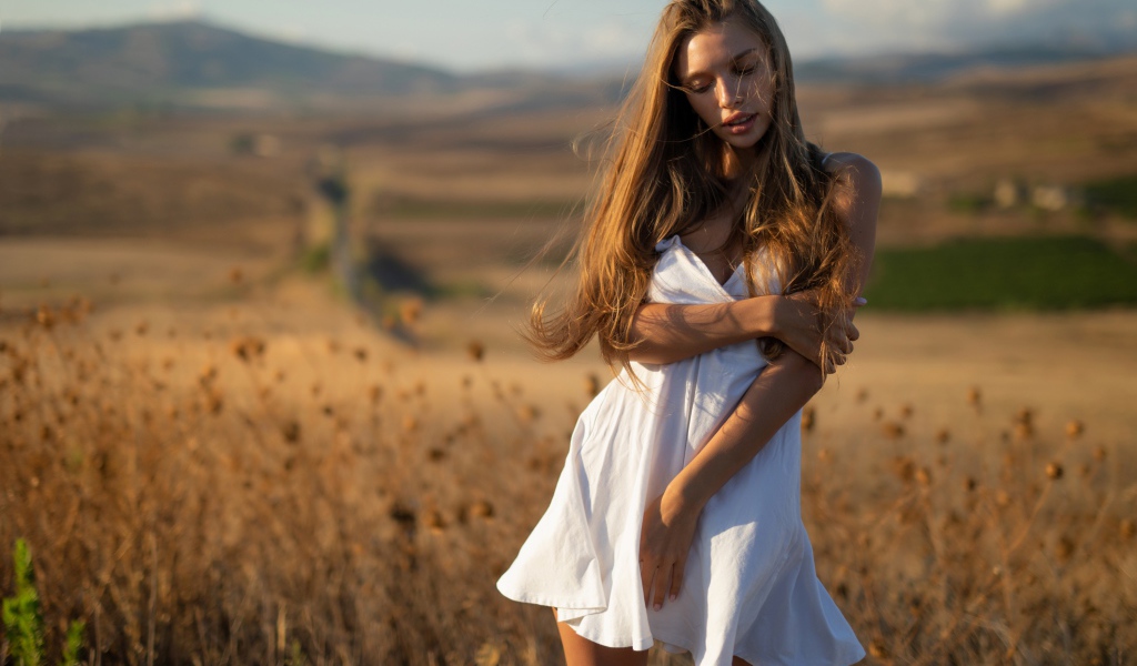 Нежная девушка в белом платье в лучах солнца 