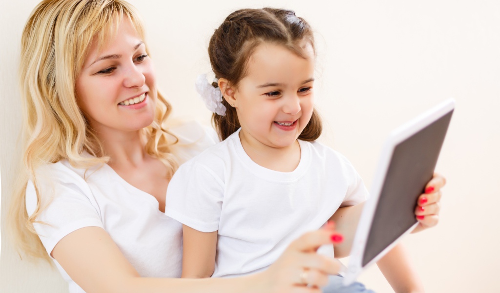 Женщина с маленькой девочкой сидят на  диване