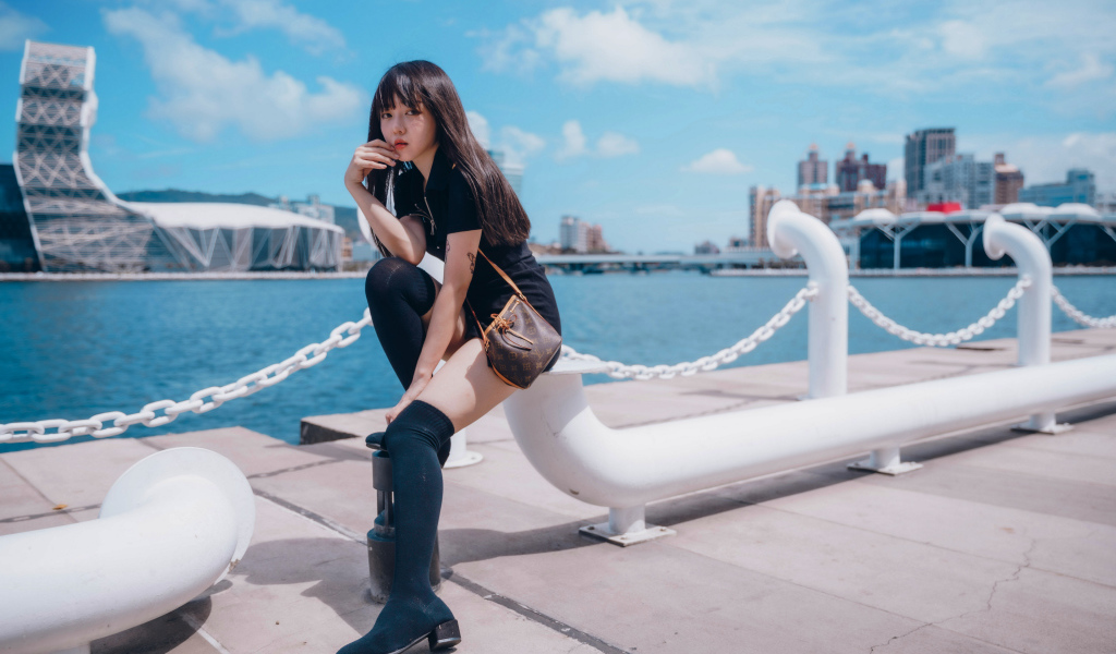 Молодая азиатка сидит в порту 