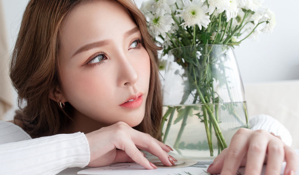 Молодая азиатка с букетом белой хризантемы в вазе