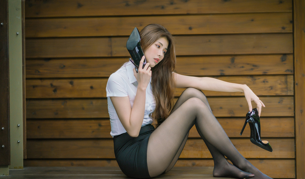 Молодая азиатка с черными туфлями в руках 