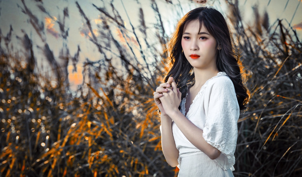 Молодая девушка азиатка в белом платье на закате