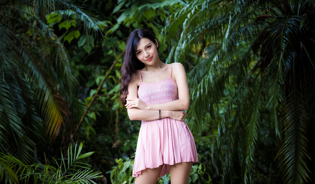 Молодая девушка азиатка на фоне зеленых листьев