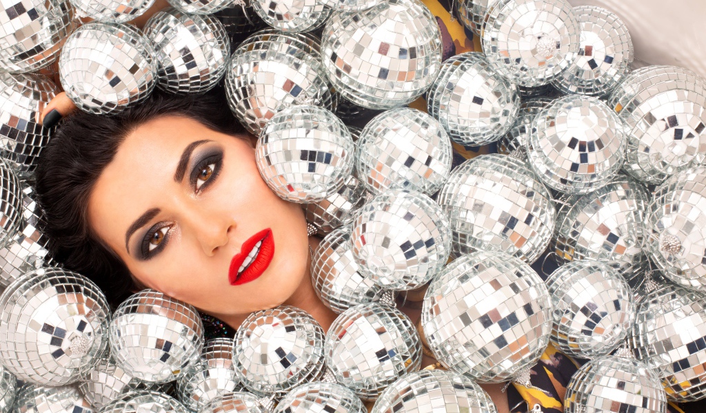 Молодая девушка усыпана блестящими шарами