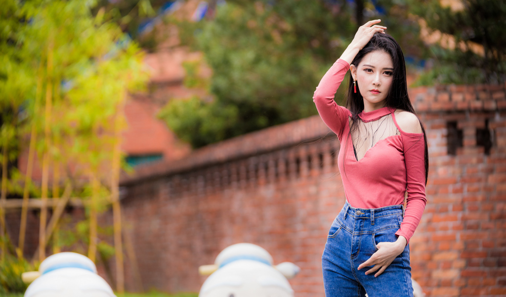 Молодая стройная азиатка в джинсах 