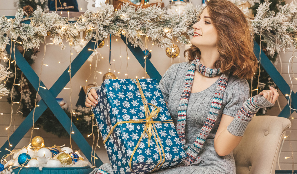 Красивая девушка с большим подарком на Рождество
