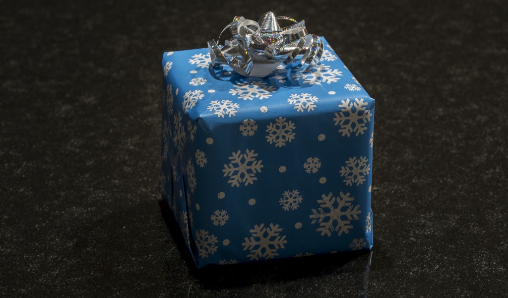 Большой голубой подарок с бантом на черном фоне 