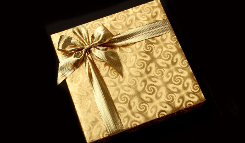 Золотая упаковка с подарком на черном фоне
