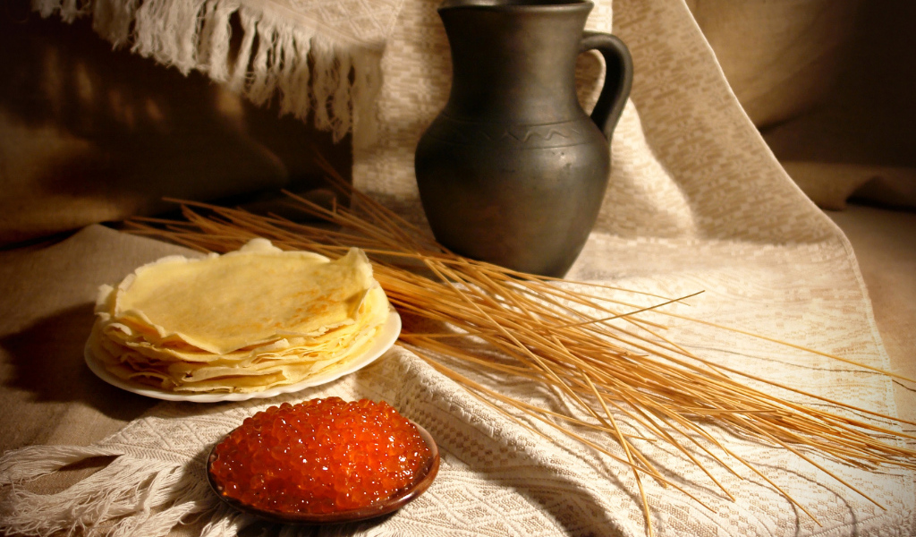 Блины с икрой на столе с колосьями на праздник Масленица