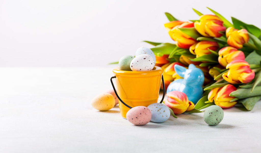 Букет тюльпанов на белом фоне с крашеными яйцами на Пасху