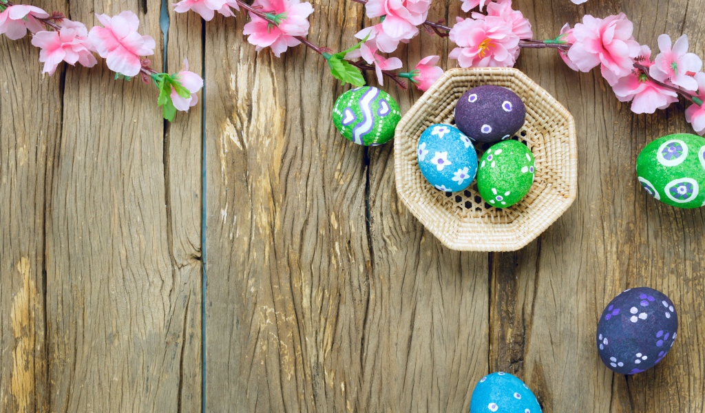 Яркие разноцветные яйца с розовыми цветами на Пасху