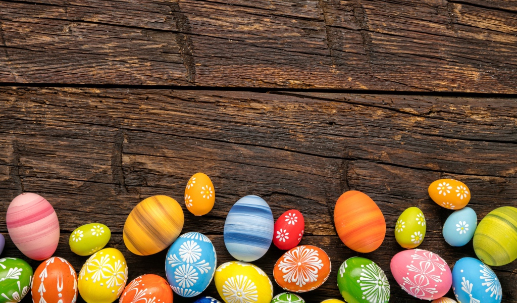 Разноцветные пасхальные яйца на деревянном столе