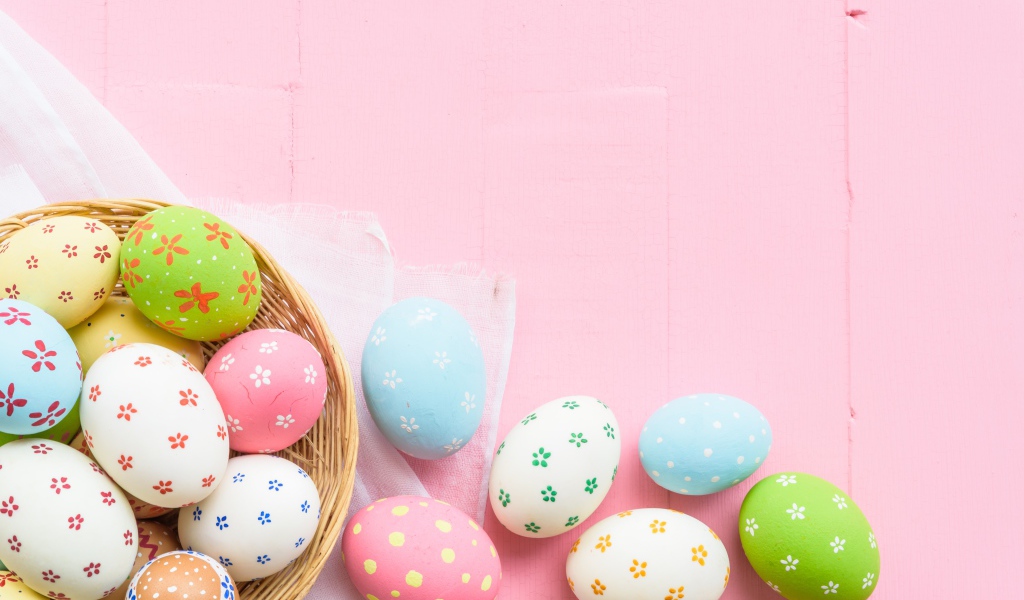 Разноцветные пасхальные яйца на розовом фоне