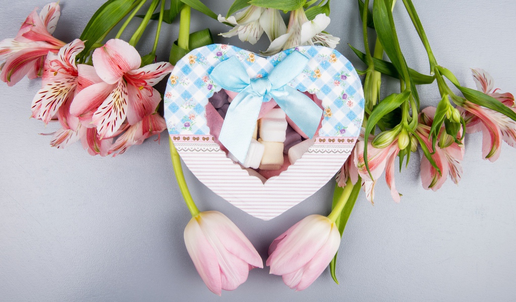Коробка конфет в форме сердца и цветы на сером фоне на 8 марта