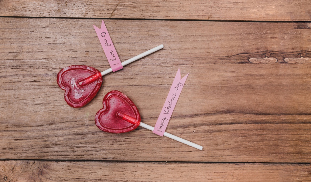 Два красных леденца для любимой на деревянном столе