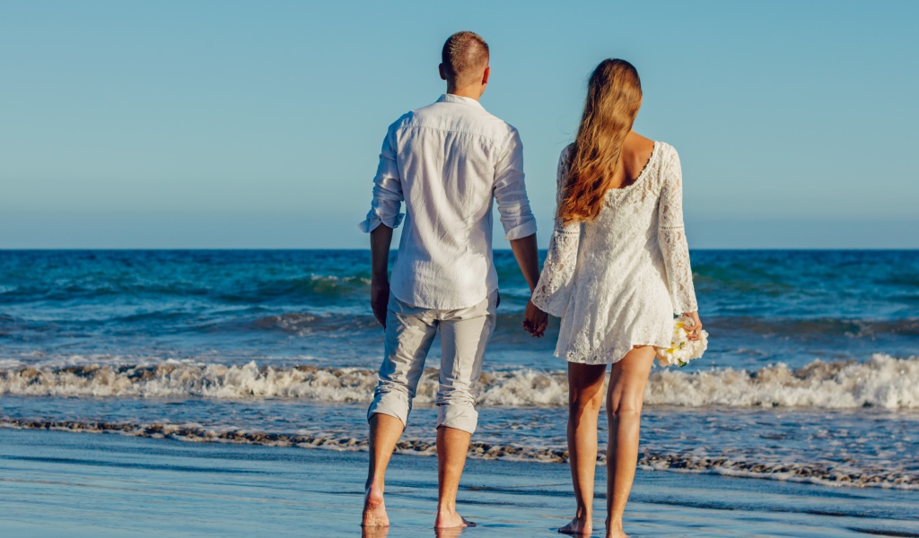 A loving couple walks along the seashore