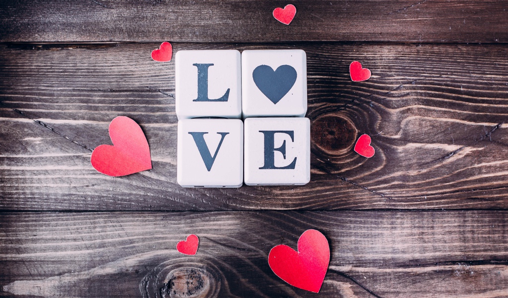 Кубики  с надписью любовь с сердечками на деревянном столе