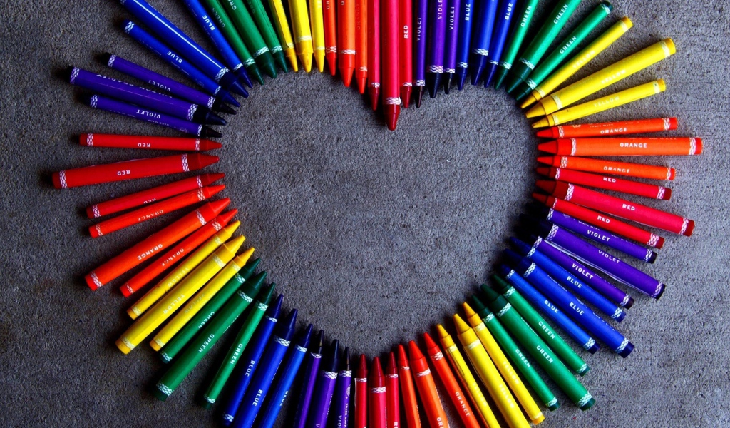 Сердце  из разноцветных карандаш на сером фоне 